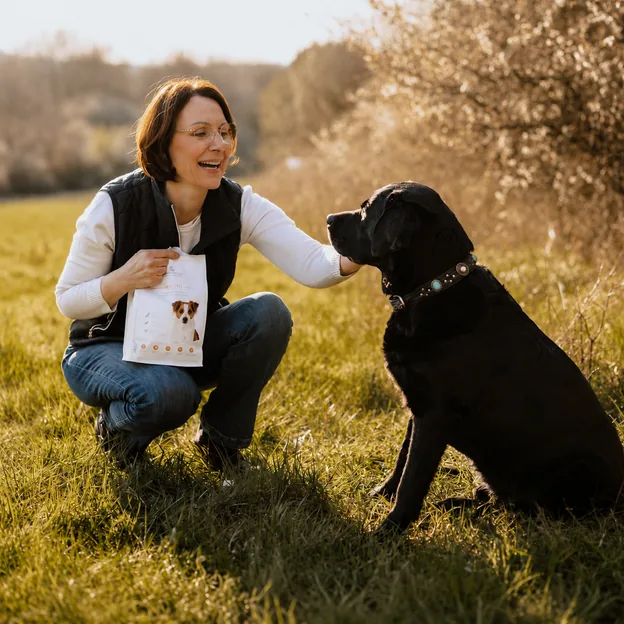Hund und Mensch mit Futtersack in der Natur