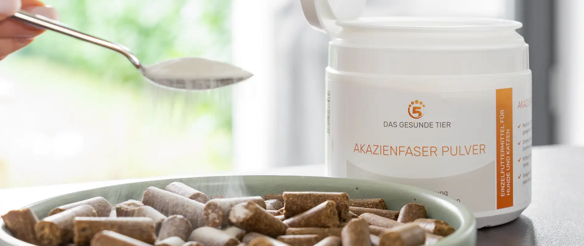 Akazienfaser Pulver wird über Hundefutter gestreut zur Unterstützung der Darmgesundheit.