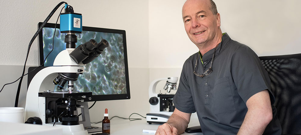 Tierarzt Thomas Backhaus vor dem Mikroskop bei einer Vitalblutanalyse
